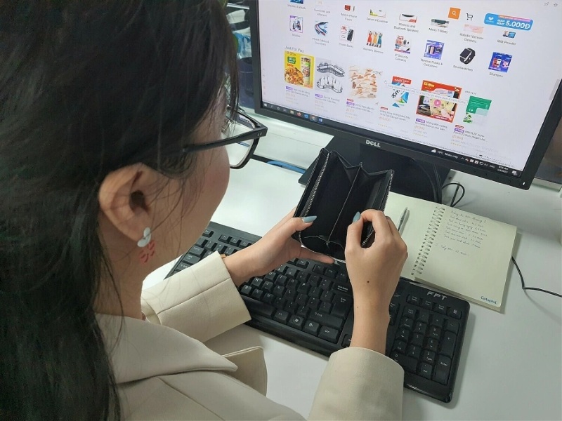 Người phụ nữ trẻ quản lý chi tiêu bằng ứng dụng tài chính tại quán cà phê
