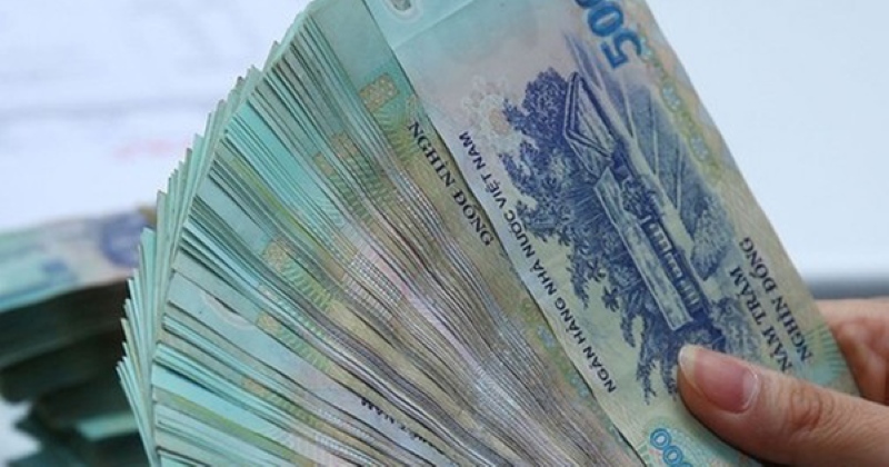 Người dân kiểm tra tờ tiền polymer mới dưới ánh sáng để xác thực