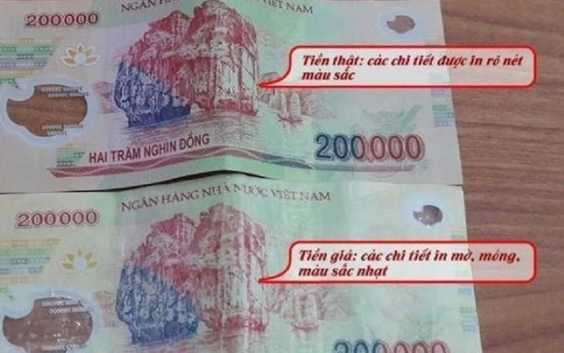 Người dân Việt Nam soi tờ tiền polymer mới để kiểm tra bảo an